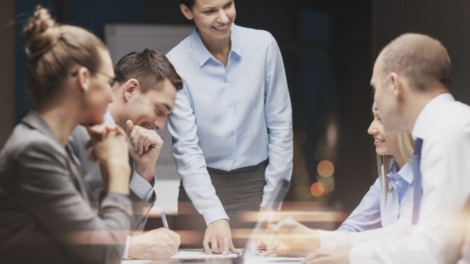 smiling female boss talking to business team work presentation