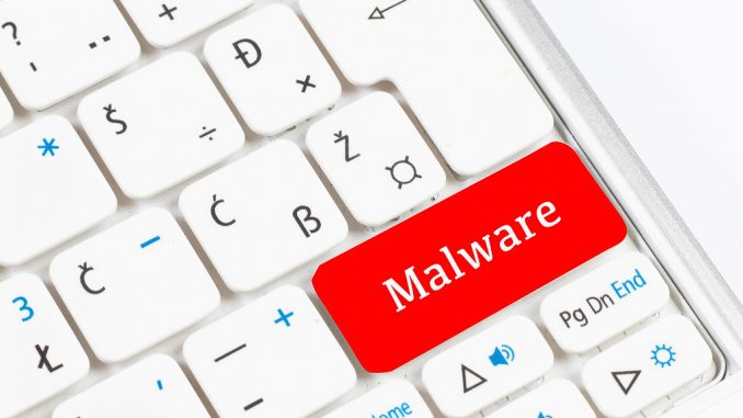 Red malware button on white keyboard